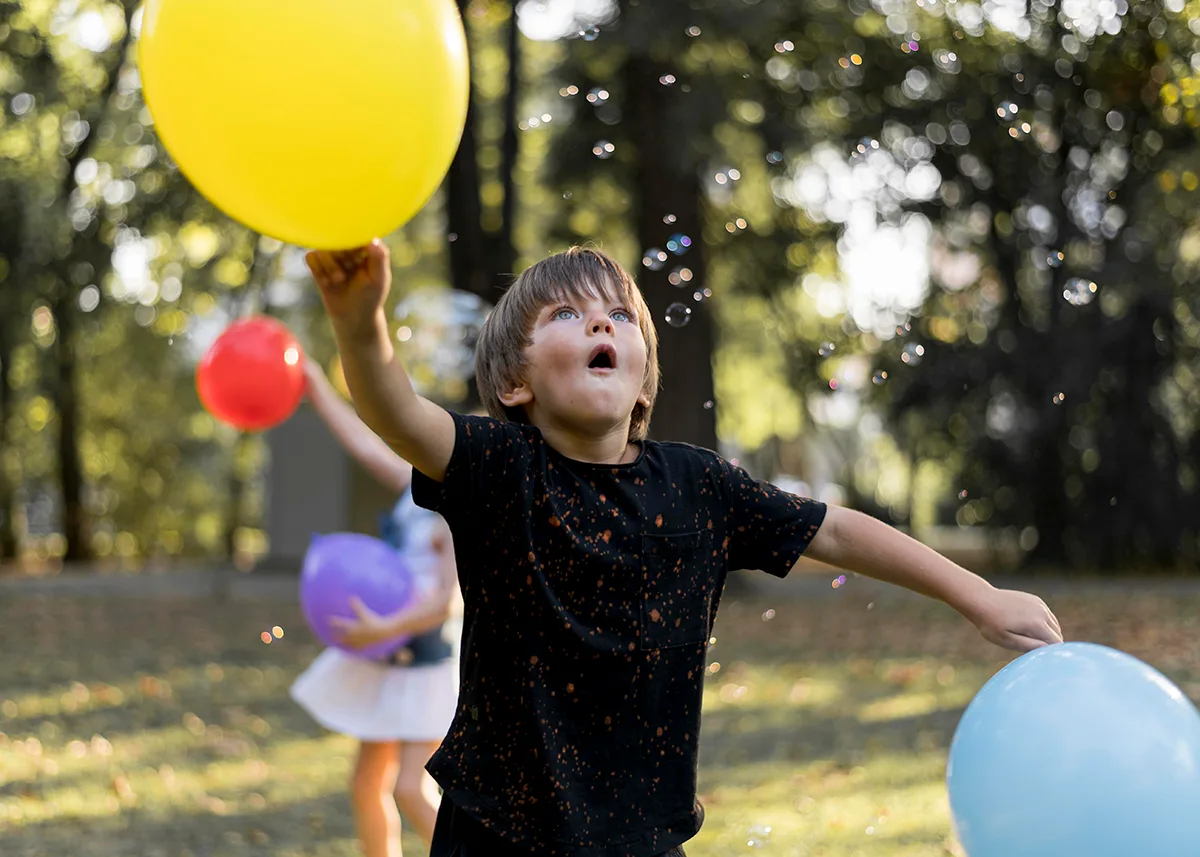 niño jugando con globos