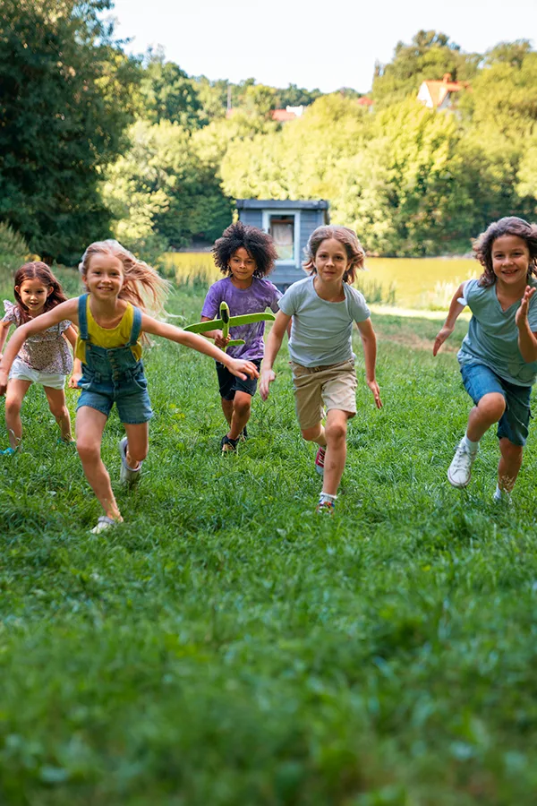 outdoors niños y niñas corriendo sobre la hierba